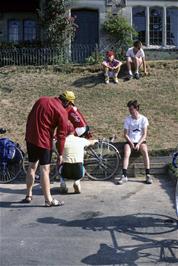 Richard Hopper checks Ken's work as he adjusts Julie's bike outside Beer YH - John, Toby and Shane prefer to enjoy the sun!