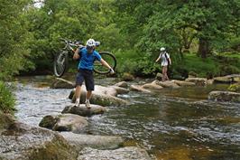 Ash helps his friend across the stepping stones