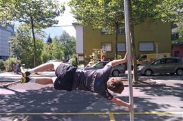 Ash does his pole trick one last time for John to catch on his phone, outside Interlaken Youth Hostel