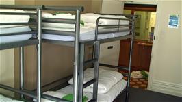 The adequate metal bunks in our ground floor dorm at Burley Youth Hostel, with the hostel reception desk just opposite