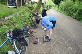 Tao repairs his puncture by the café at Boscarne