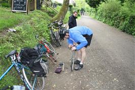 Tao repairs his puncture by the café at Boscarne