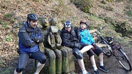 Tao, Dillan and George sit with the bench sculptures on the Tarka Trail near Great Torrington, 28.1 miles into the ride
