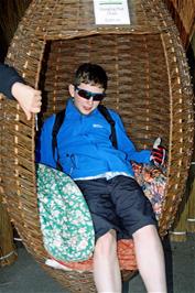 George tries out a wicker Hanging Pod Chair at the Willows and Wetlands Centre
