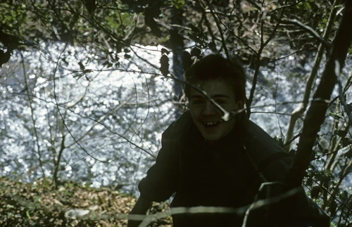 Paul Williams by the River Heddon, grinning as sunlight dances on the water below Broadoak Hill.