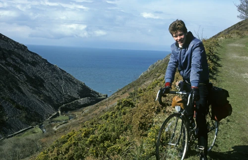 Jonothan on the coast path above Heddon’s Mouth, sunshine and sea stretching away behind him.