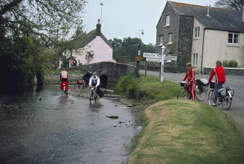 Gary leads the water-lovers riding bikes through the shallows at South Pool Creek's head; Warren and Paul watch.