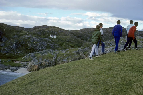 Five of us on the grassy headland between Achmelvich’s two silver‑sand beaches; Vesteys Beach behind.