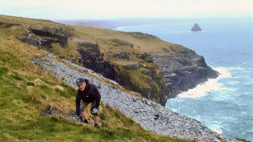 Josh larks about on the soft grass outside Tintagel YH.