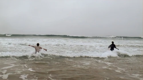 Determined to enjoy a beach, both lads wade in wearing full cycling kit.