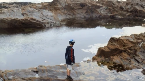 Josh inspects the enormous rock pool at Treyarnon Bay.