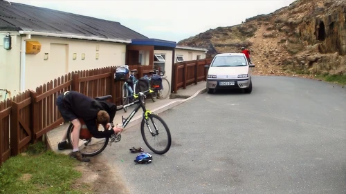 Joe oils his chain outside Perranporth youth hostel.