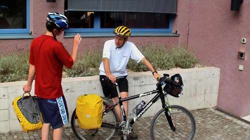 Joe chats with Michael at Zurich Youth Hostel as he prepares his bike for departure.