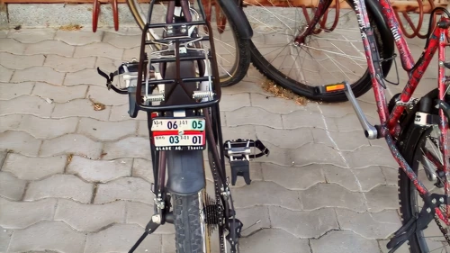 Licence plates linger on old bikes outside Volg, Zillis—redundant since 1988.