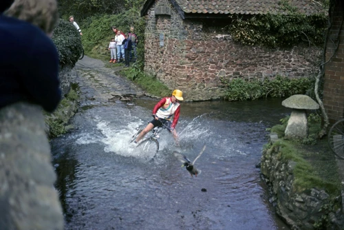 Simon Hopper comes a spectacular cropper halfway across the Allerford ford, scattering ducks.