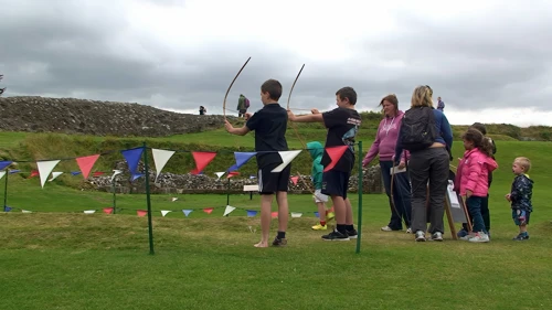 George and Dillan try their hand at archery at Old Sarum