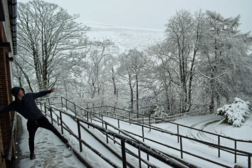 George tries shot put with snowballs outside Edale Youth Hostel.