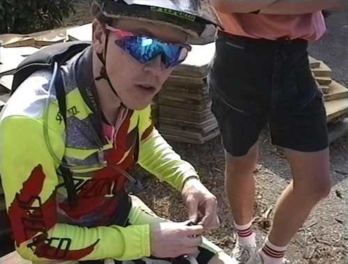 Julian reminds Mum to record Thursday’s mountain bike race while fettling Matthew’s helmet.