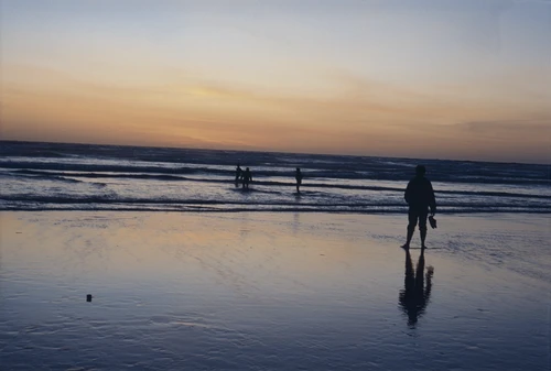 20 Apr 1987 · Wading the shallows at Perranporth as the sun slips away.