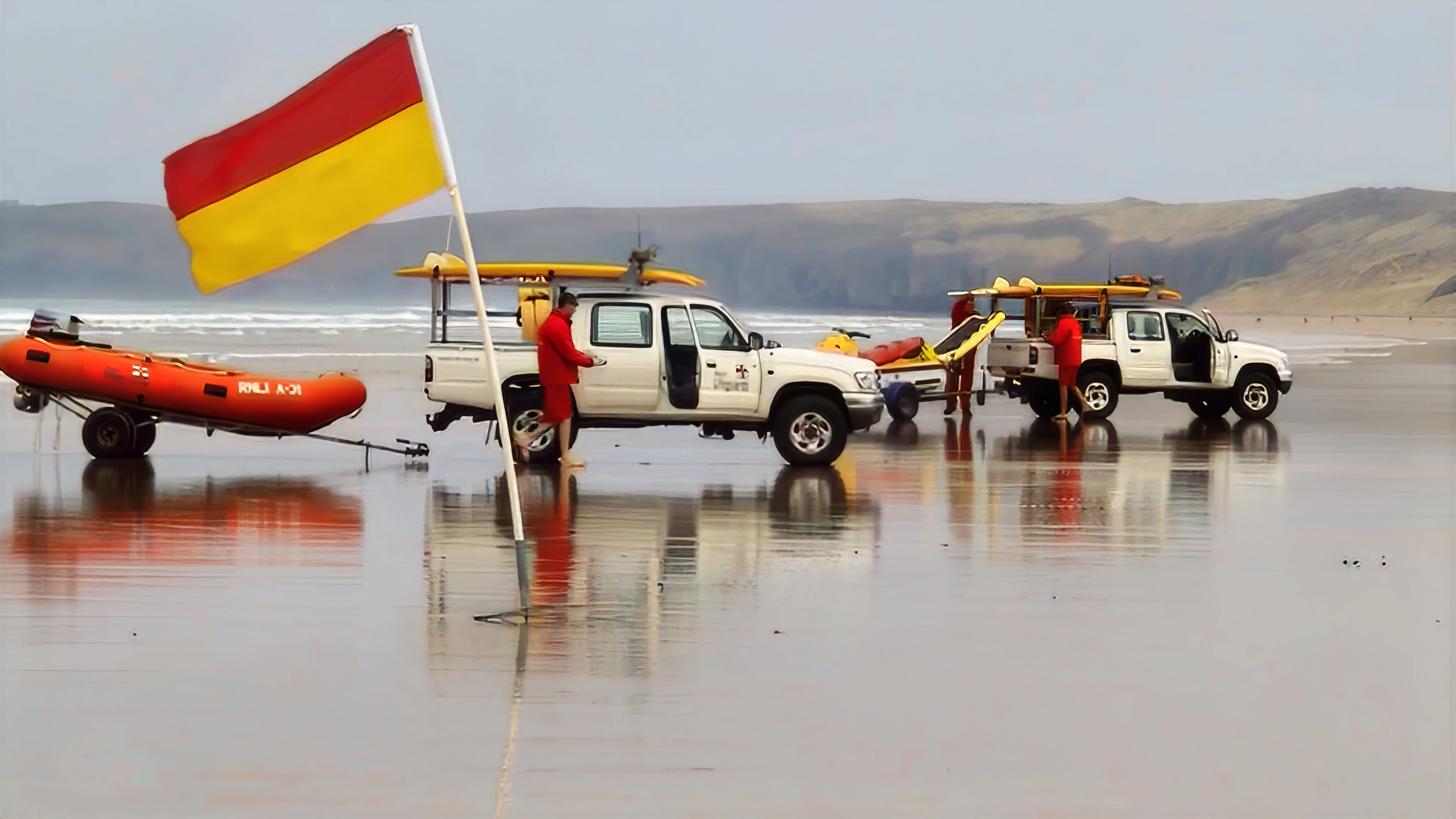 Lifeguards on Perranporth Beach, shuffling along with the tide.