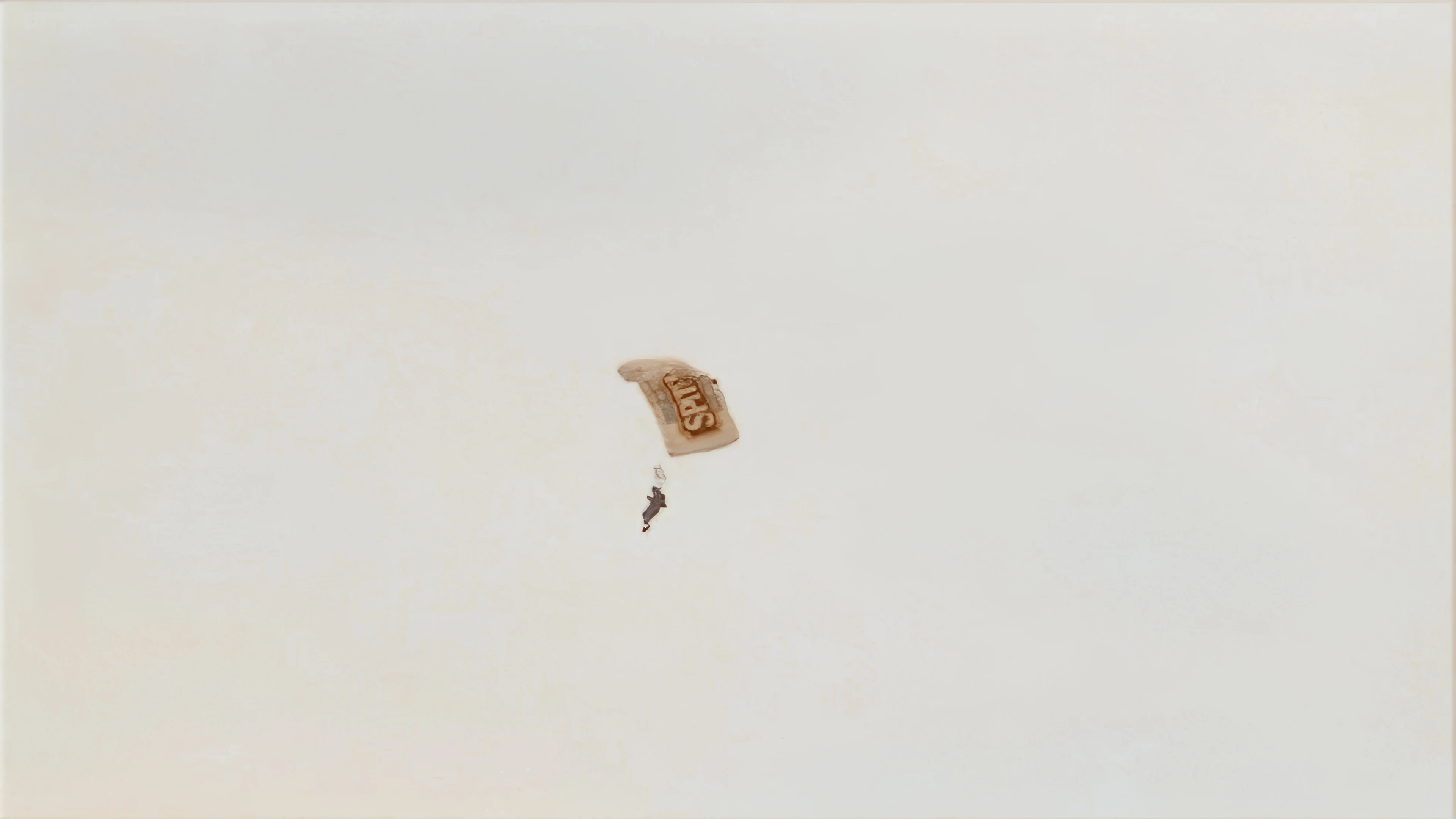 A paraglider descends to Perranporth Airport, seen from the Coast Path.