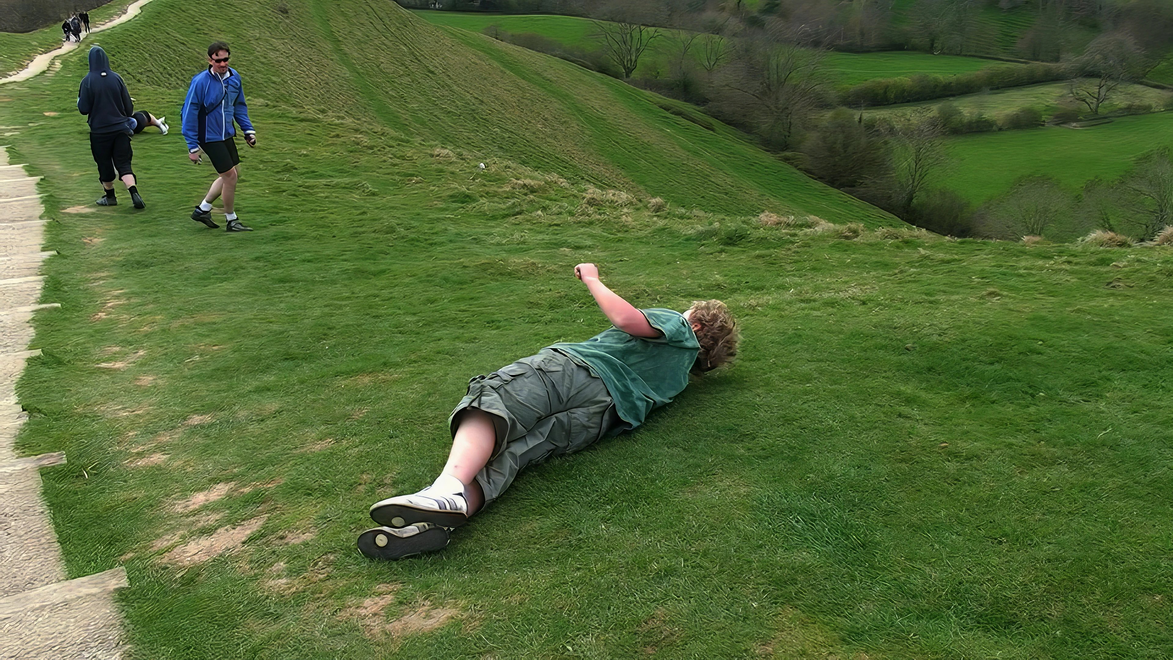 The youngsters take it in turns to roll from the top of Glastonbury Tor